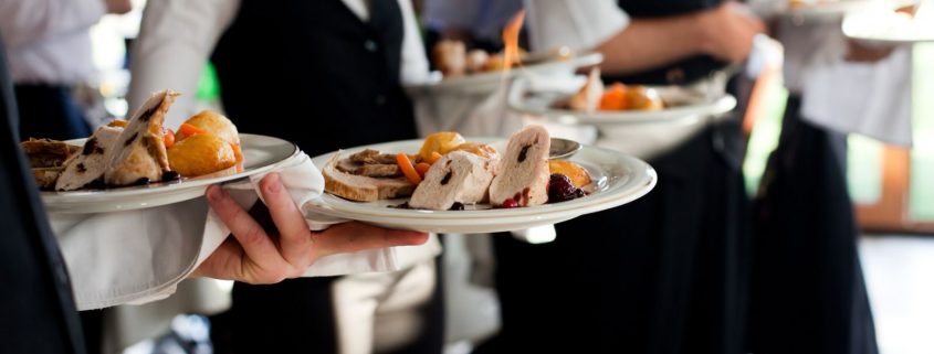 Veranstaltungen in der Gastronomie. Zu sehen sind Servicekräfte, die perfekt angerichtete Teller tragen