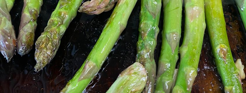 vegane gastronomie grüner spargel liegt auf einer Grillplatte in einer Gastronomie